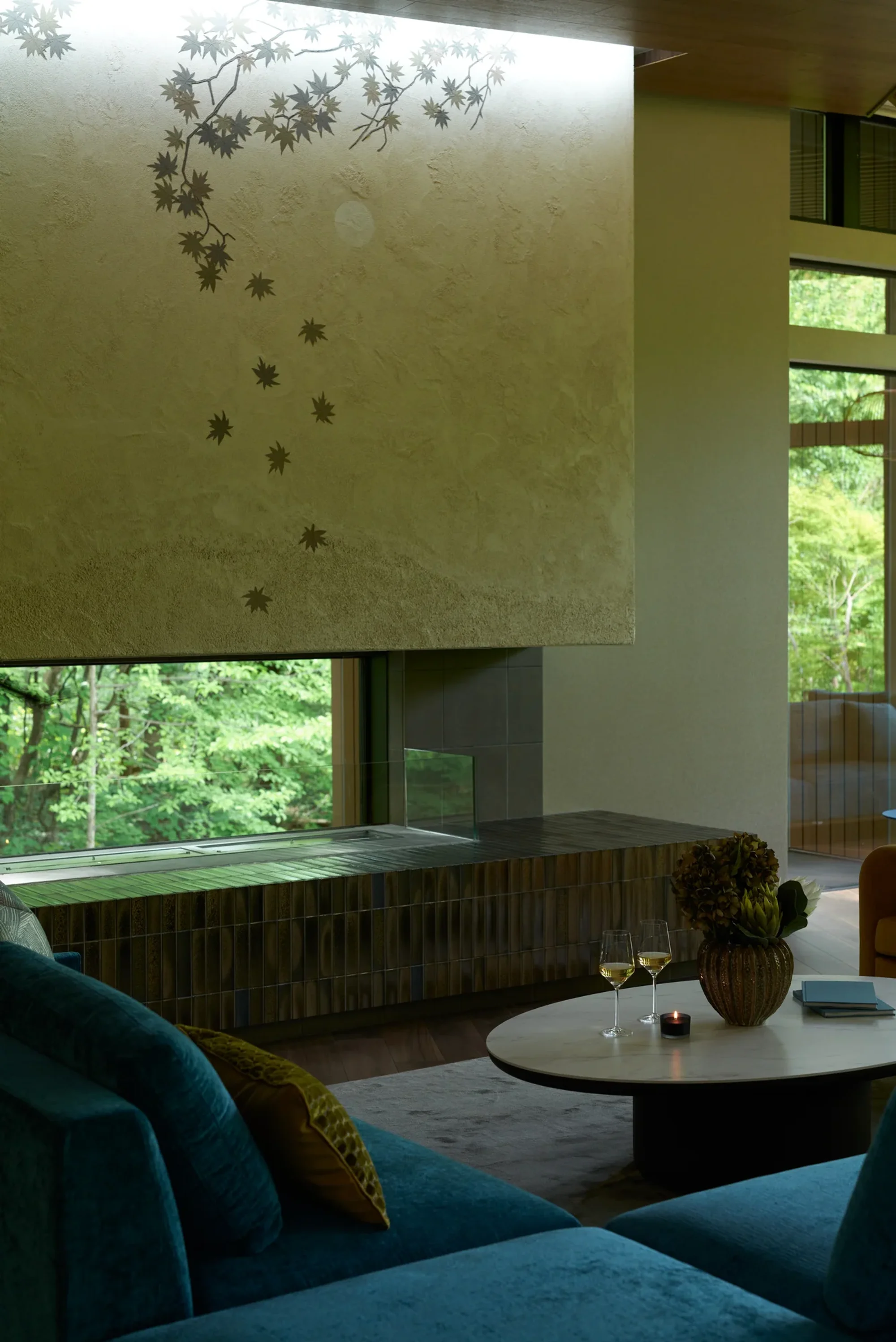 A fireplace and low table beside blue seating