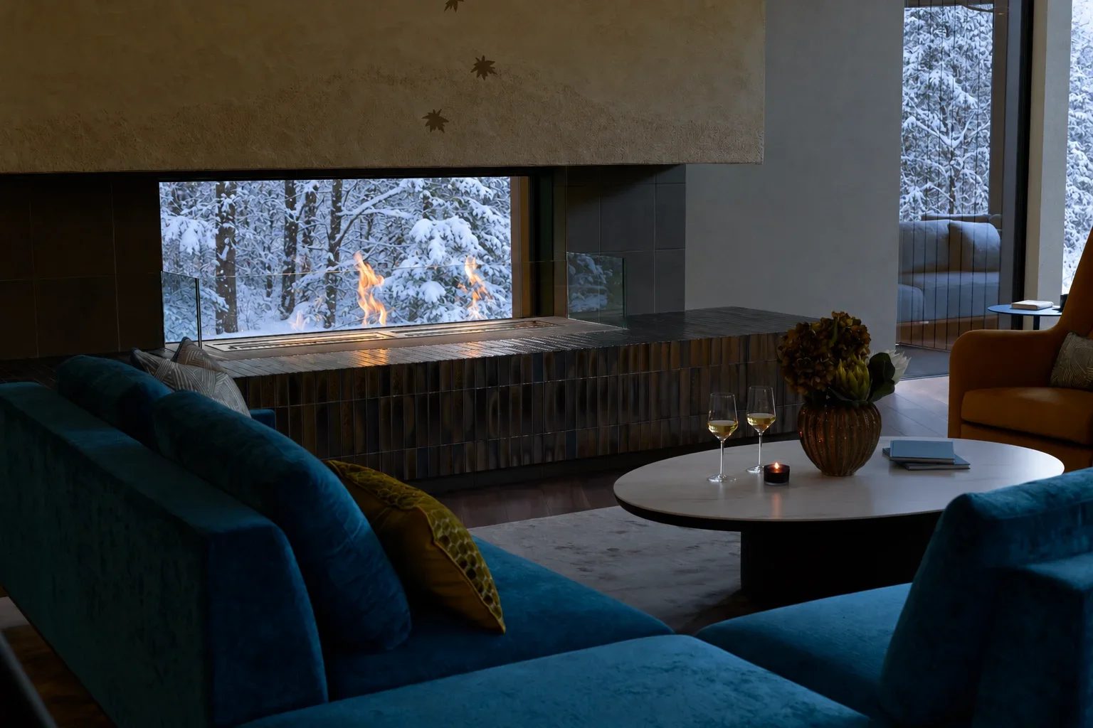 A glass fireplace with a snowy forest beyond it